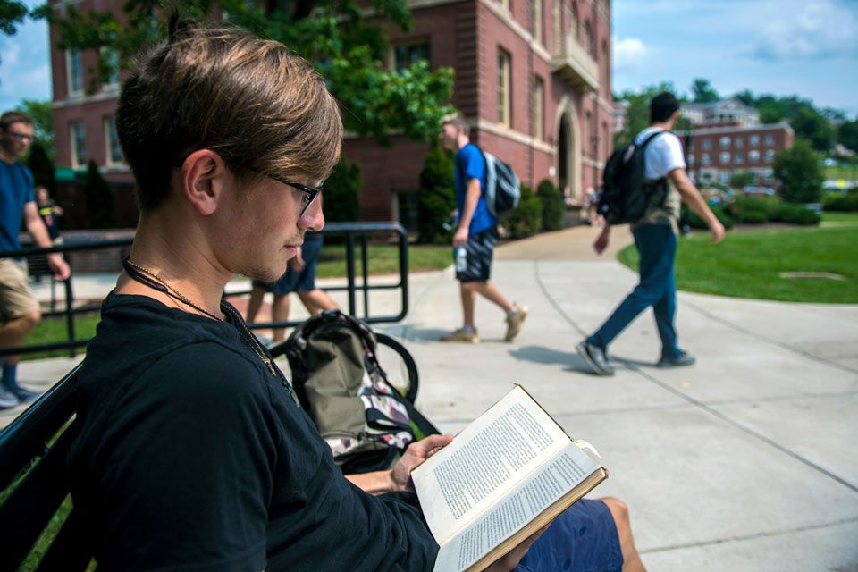 Student reading book on campus
