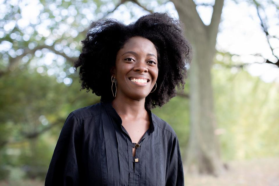 Yaa Gyasi stands outside in the woods.